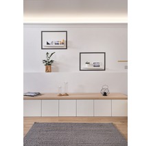 Woonkamer met houten vloer, grijs vloerkleed, dressoir en wandplanken