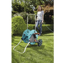 Tuinslangwagen met slang en vrouw in de tuin