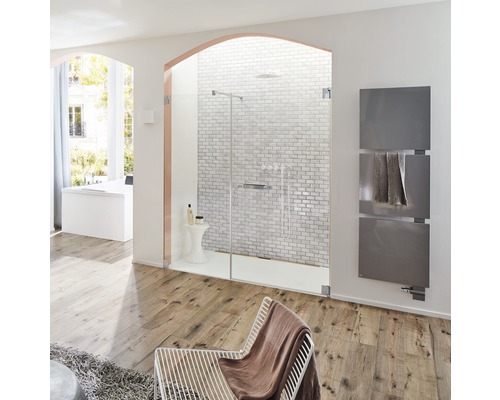 Lichte badkamer met douche, handdoekradiator, fauteuil en houten vloer