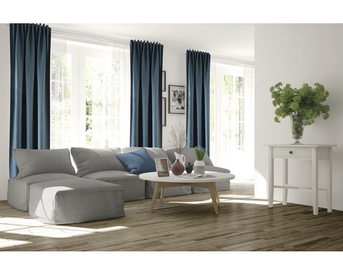 Woonkamer met bank, salontafel, gordijnen en houten vloer