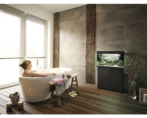 Badkamer met vrijstaand bad, aquarium en houten vloer voor een ontspannen sfeer