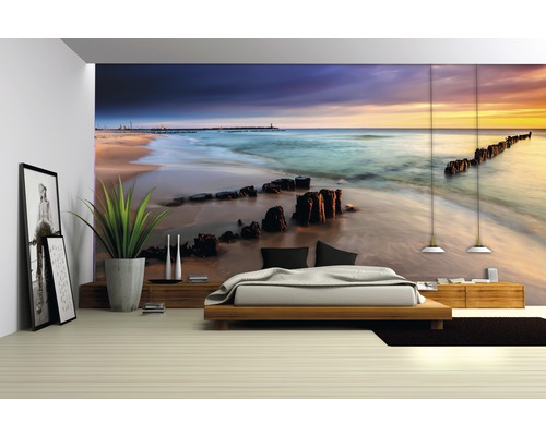 Slaapkamer met fotobehang van een strand bij zonsondergang