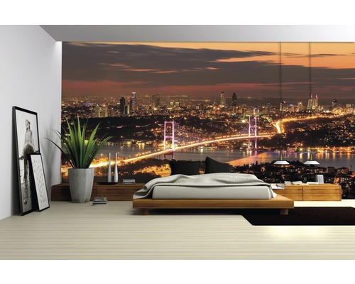 Slaapkamer met fotobehang van een nachtelijk stadsgezicht met brug