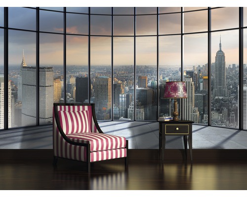 Woonkamer met fauteuil, tafel en uitzicht op de stad