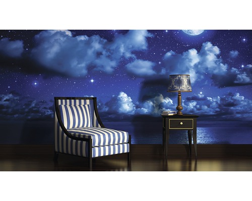 Woonkamer met fauteuil, nachtkastje en fotobehang met nachtmotief