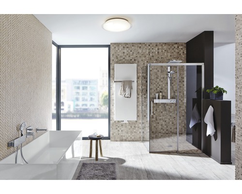 Lichte badkamer met bad, douche en radiator