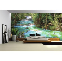 Kamer met fotobehang met watervalmotief achter een bed
