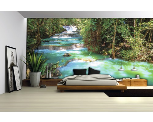 Kamer met fotobehang met watervalmotief achter een bed