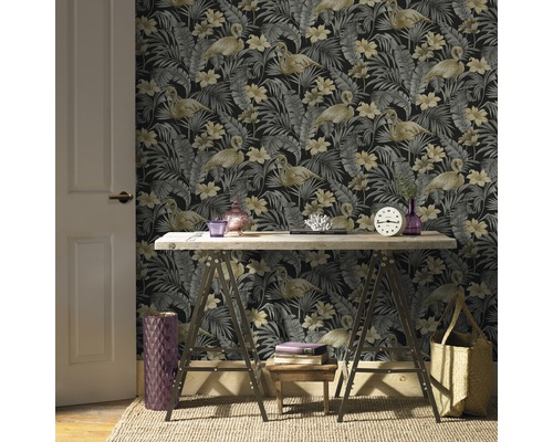 Kantoorruimte met een patroonbehang met flamingo''s en tropische bladeren, een houten tafel op schragen en decoratieve elementen.