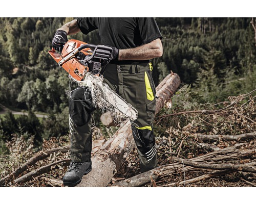Boswachter met kettingzaag en veiligheidsbroek aan het werk