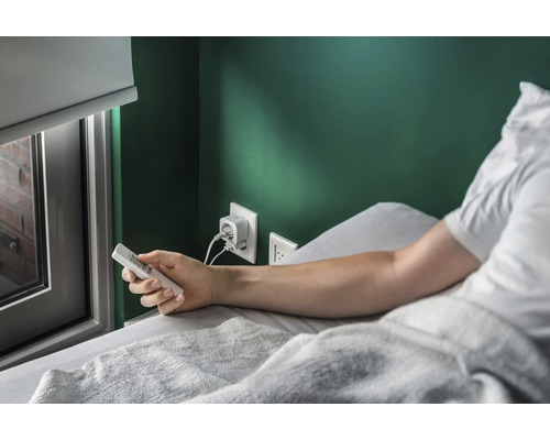 "Persoon ligt in bed en bedient een afstandsbediening