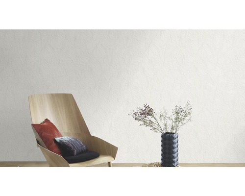 Woonkamer met een wit reliëfbehang, een houten stoel en een tafel met bloemen