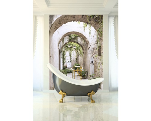 Badkamer met een vrijstaand bad en een fotoprint van een steeg met stenen bogen