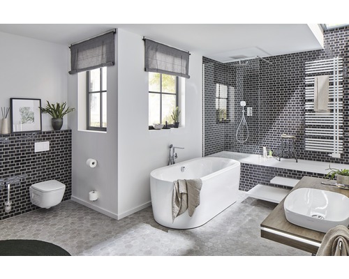 Lichte badkamer met bad, wastafel, toilet en douche