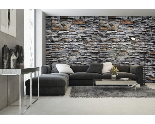 Woonkamer met stenen behang, bank, tapijt en salontafel.