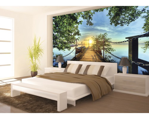 Slaapkamer met foto van een houten steiger bij zonsondergang over een meer