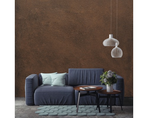 Woonkamer met blauwe bank, salontafel, vloerkleed en hanglampen voor een wand
