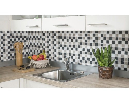 Keukenspoelbak met kraan, mozaïektegels en keukengerei op een aanrecht