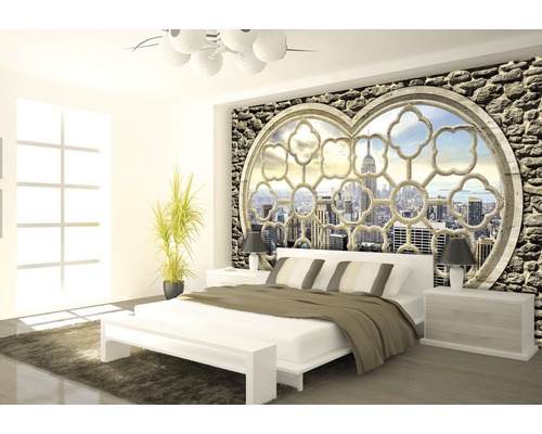 Lichte slaapkamer met tweepersoonsbed en wandbehang met stenen en uitzicht op een stad