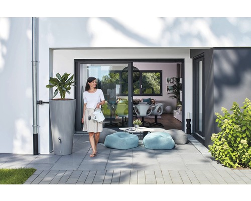 Scène met regenwatertank, plant, vrouw met gieter, zitzakken en terras