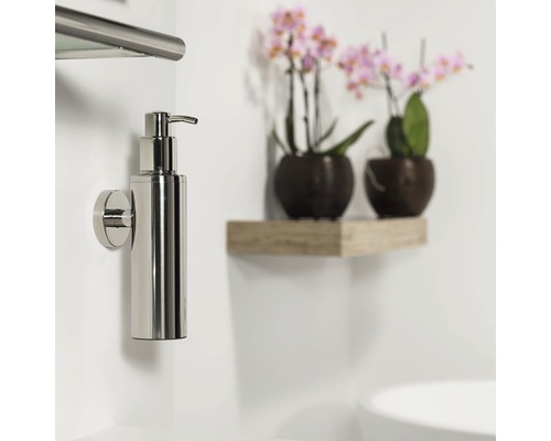 Aan de muur gemonteerde metalen zeepdispenser in de badkamer