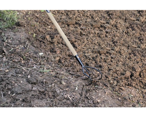 Tuinvork met houten handvat in de grond