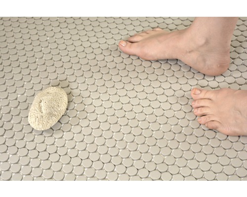 Mozaïektegels op de vloer met puimsteen en voeten