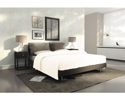 Slaapkamer met bed, nachtkastje en decoratief wandbehang