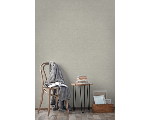 Lichte kamer met beige vliesbehang, stoel, tafel en decoratie