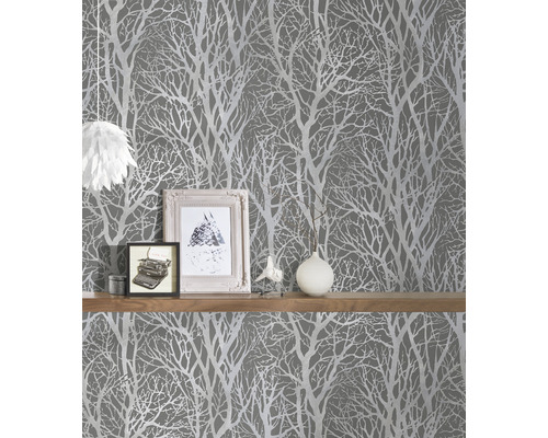 Scène met grijs behang met boommotief en een plank met decoraties.
