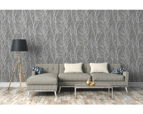Woonkamer met grijs behang met boommotief, bank, vloerlamp en salontafel