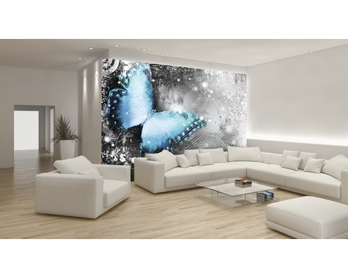 Woonkamer met fotobehang met vlindermotief, lichte inrichting en houten vloer.