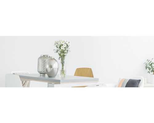 Lichte eetkamer met tafel, stoelen, bloemen en decoratieve vazen