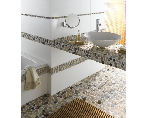 Badkamer met wastafel, spiegel en kiezelvloer