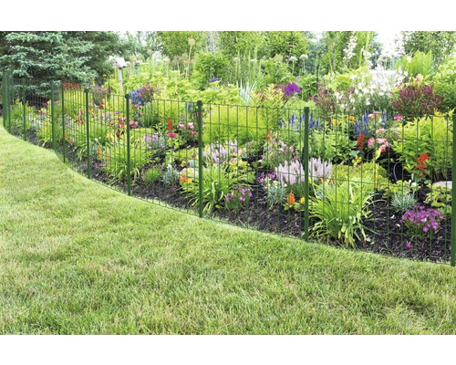 Tuinhek van metaaldraad naast bloembed