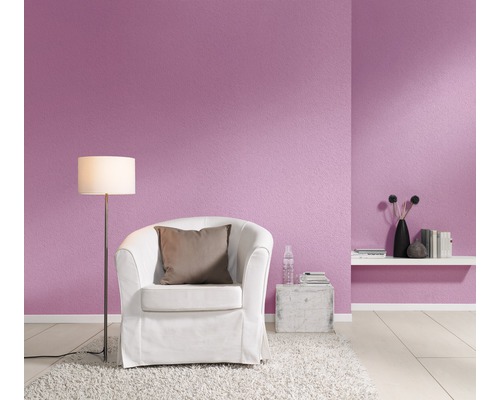 Woonkamer met fauteuil, vloerlamp en decoratieve muur