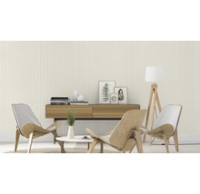 Woonkamer met gestreept behang, houten meubels en decoratieve elementen.