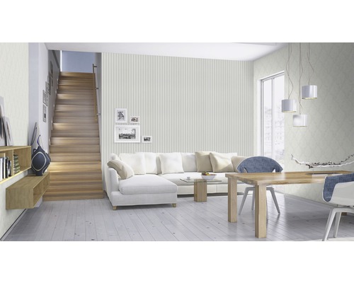 Lichte woonkamer met trap, bank, eettafel en behang met patroon