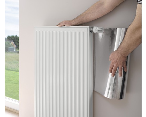 Installatie van radiatorfolie achter een radiator voor warmtereflectie.