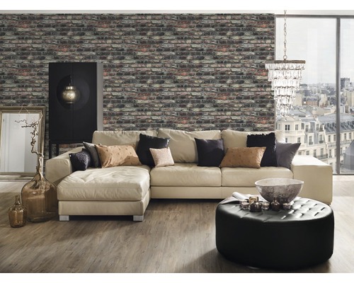 Woonkamer met bakstenen behang, hoekbank, voetenbanken, kast en decoratieve elementen voor een gezellige sfeer.