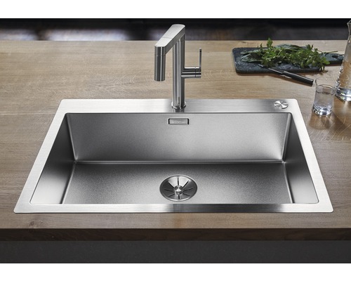 Spoelbak van roestvrij staal met kraan op een houten oppervlak