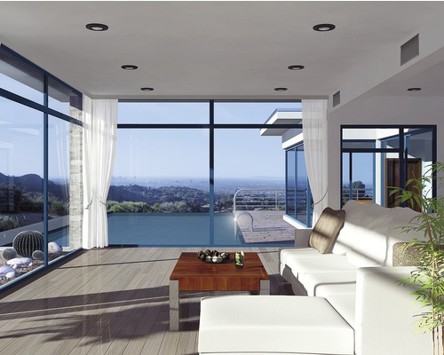 Lichte woonkamer met grote ramen, plafondlampen en een moderne inrichting