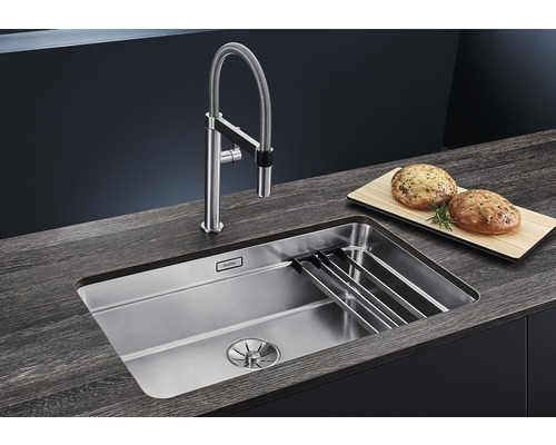 Roestvrijstalen spoelbak met kraan en snijplank op een werkblad