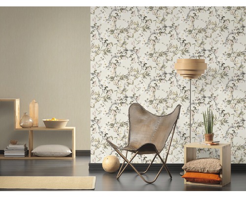 Woonkamer met patroonbehang, fauteuil en houten stellingen