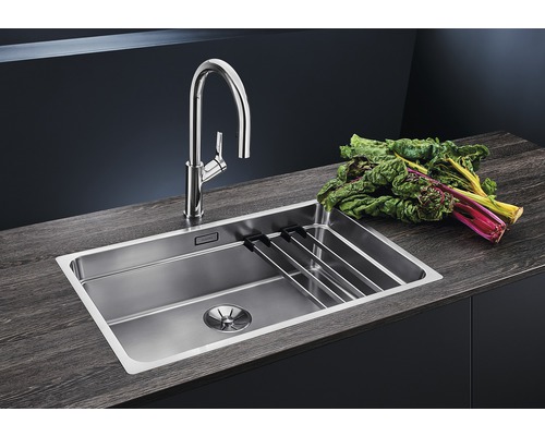 Roestvrijstalen spoelbak met afdruiprek en kraan op een werkblad