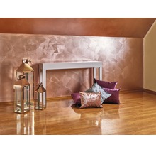 Interieur met decoratieve wanddecoratie, witte consoletafel, sierkussens en metalen lantaarns op houten vloer