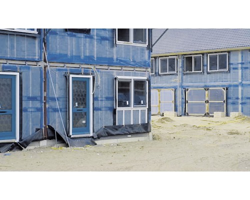 Ruwbouw van een appartementencomplex met blauwe gevelbekleding, ramen en deuren.