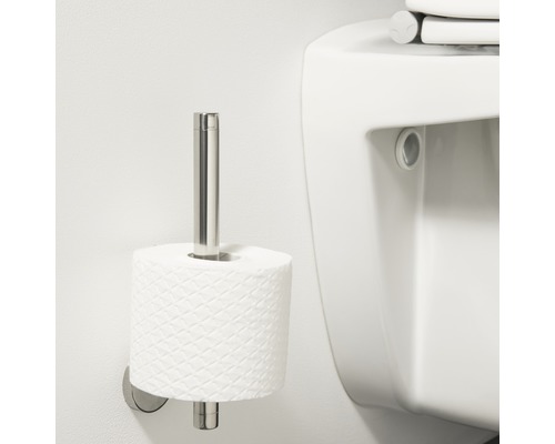 Metalen toiletpapierhouder met toiletpapier naast een toilet