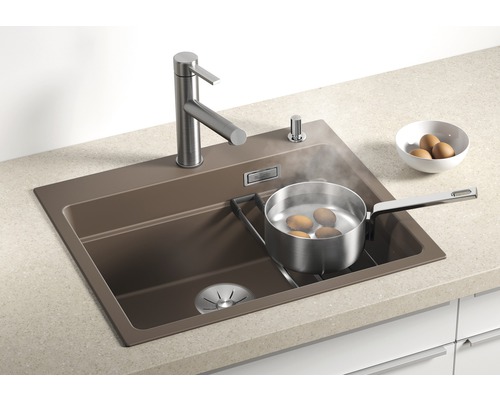 Spoelbak met kraan, zeepdispenser en pan met kokende eieren