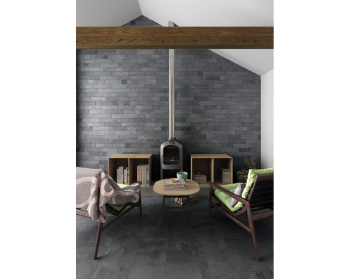 Woonkamer met open haard, twee fauteuils, salontafel, betegelde muur en betegelde vloer